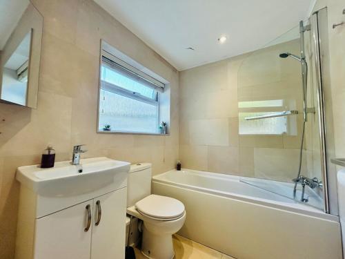 a bathroom with a sink and a toilet and a bath tub at Benson House Box in Box