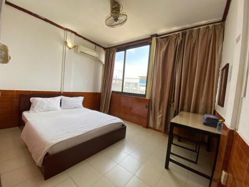 a hotel room with a bed and a window at Intouch Guest House in Vientiane