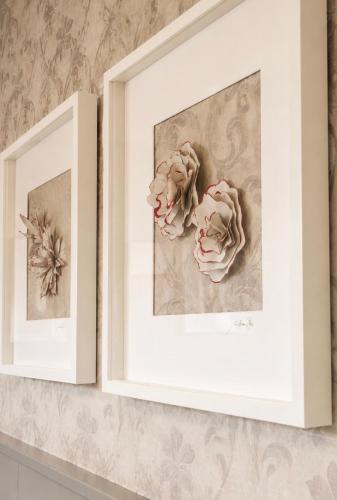 two framed prints of roses on a shelf at Hotel La Pace in San Mauro Torinese