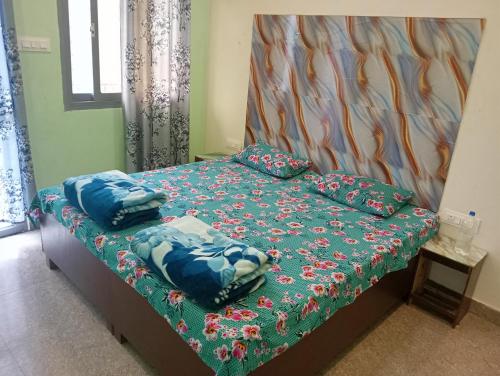 a bed with a green comforter and pillows on it at Krishna Hotel & Restaurant in Devaprayāg
