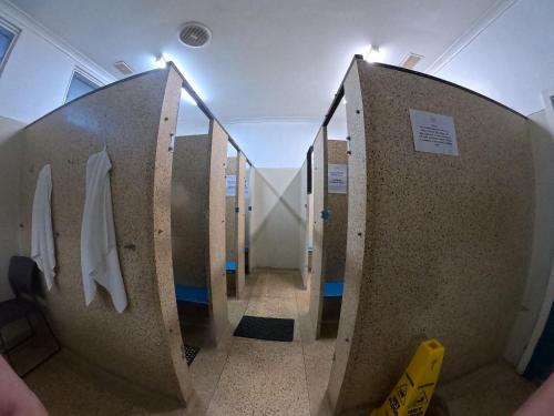 a hallway of a public bathroom with a toilet at 1849 Backpackers at The London in Albany