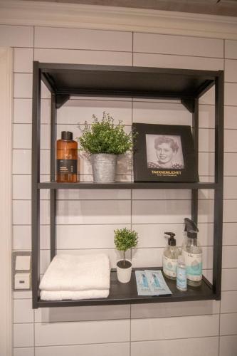 a shelf with towels and plants on it in a bathroom at Auntie Laurentze's house in Haugesund