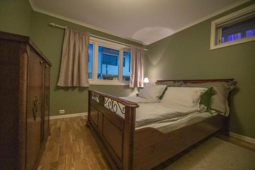 a bedroom with a wooden bed with a window at Auntie Laurentze's house in Haugesund