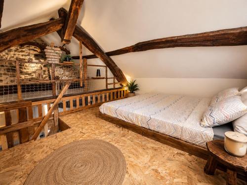 a bedroom with a bed in a room with wooden beams at Le Nid du Viaur in Pampelonne