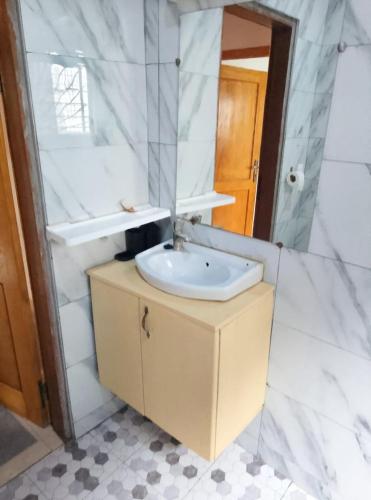 a bathroom with a sink and a mirror at Résidence Merveilles P14 in Kribi
