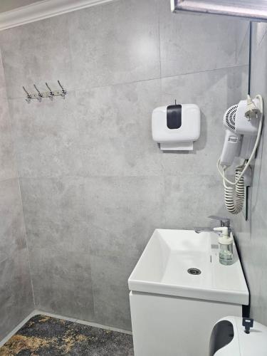 a bathroom with a white sink and a hair dryer at Osh Art Hotel in Osh