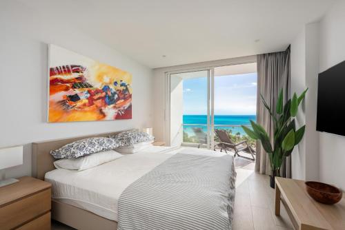 a bedroom with a bed and a view of the ocean at Mountain and Sea view apartment in Nathon Bay
