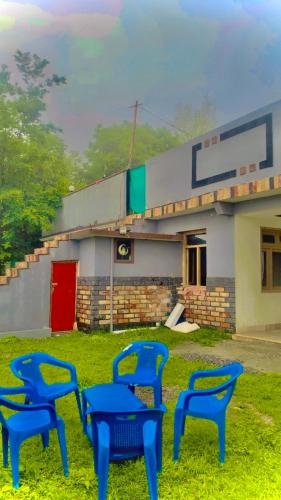 three blue chairs in front of a gas station at The Skyline Cottage in Nathia Gali