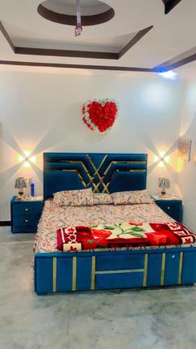 a bedroom with a bed with a heart hanging on the wall at The Skyline Cottage in Nathia Gali