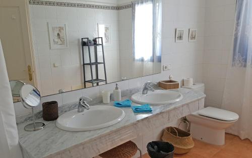 a bathroom with two sinks and a mirror and a toilet at VILLA DUNIA by Villitas in Playa Blanca