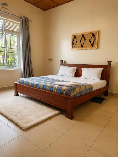 a large bed in a bedroom with a window at The Gathering in Kigali