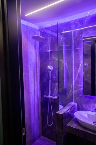 a purple bathroom with a shower and a sink at Skyline suite studio in Larisa