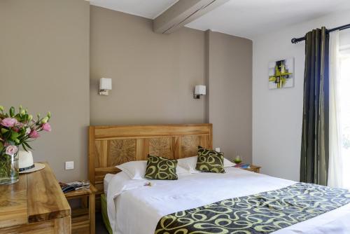 a bedroom with a bed and a vase of flowers at Domaine Du Calidianus in Sainte-Maxime