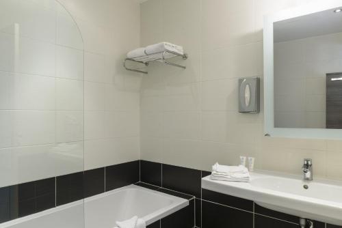 a bathroom with a sink and a tub and a mirror at Domaine Du Calidianus in Sainte-Maxime
