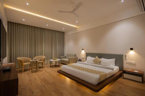 a hotel room with a large bed and chairs at Rosastays Kutch in Tuna