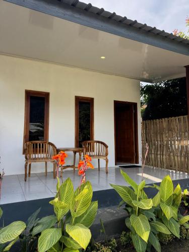 a patio with two benches and a table and some plants at JHOB Surf Stay in Maluk