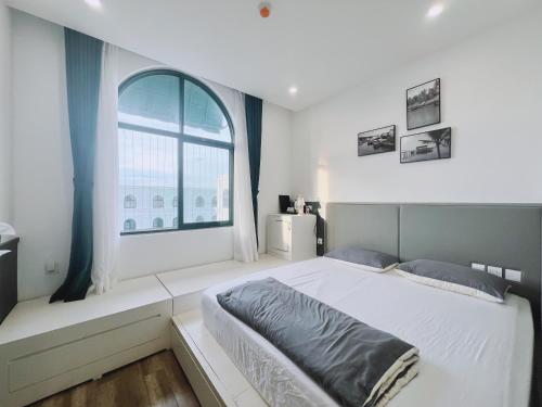 a bedroom with a large bed and a window at MARINA SEASIDE BEACH BOUTIQUE Phu Quoc - Infinity Pools - PREMIUM SOLAR ENERGY in Phú Quốc