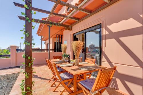 a patio with a wooden table and chairs at Villa Macaronesia Lajares Fuerteventura Remote work in Majanicho
