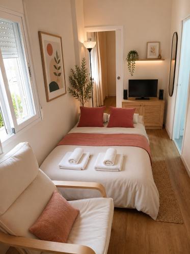 a room with two beds and a couch and a television at APARTAMENTOS VIALIA SOL y PLAYA in Málaga
