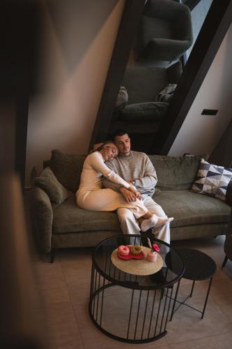 a man and a woman sitting on a couch at Nikis House Luxury Pool - Spa Villa in Ba°evac