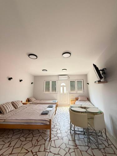 a bedroom with two beds and a table and chairs at Sobe Srebrno Jezero in Veliko Gradište