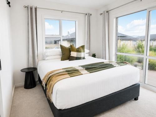 a bedroom with a large bed and a large window at The Burnby in Te Anau