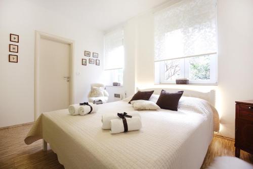 Un dormitorio con una cama blanca con toallas. en Allegro Exclusive Suites Old Town Center, en Zadar
