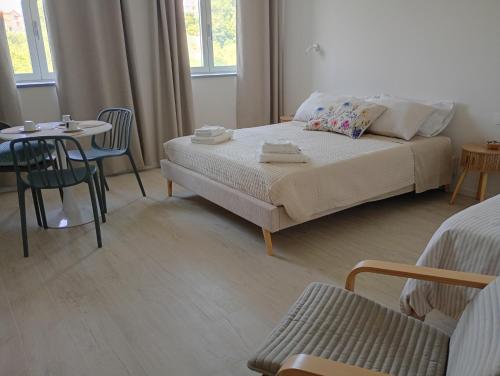 a bedroom with a bed and a table and chairs at Bed and Breakfast Casa Tortia in Cocconato