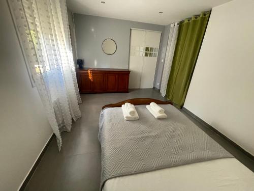 a bedroom with a bed with two towels on it at Apartment 65 m2 NE Rez de Jardin 2 chambres in Varetz