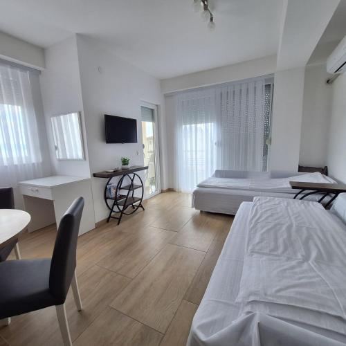 a large white bedroom with a bed and a desk at Apartments Lakeside Elesec in Ohrid