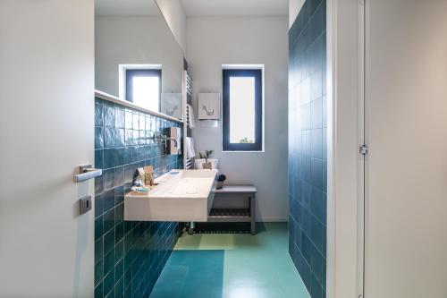 a bathroom with a white sink and blue tiles at Feudo Antico in Tollo