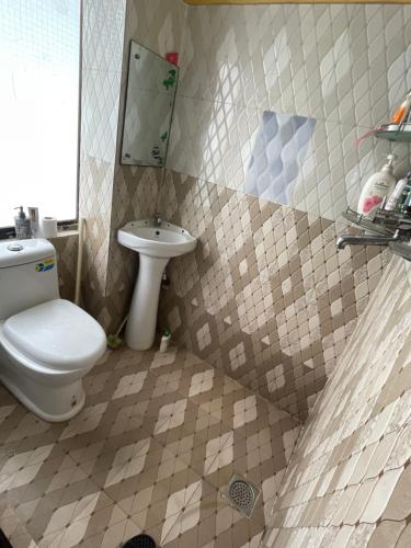 a bathroom with a toilet and a sink at Patan Nest in Pātan