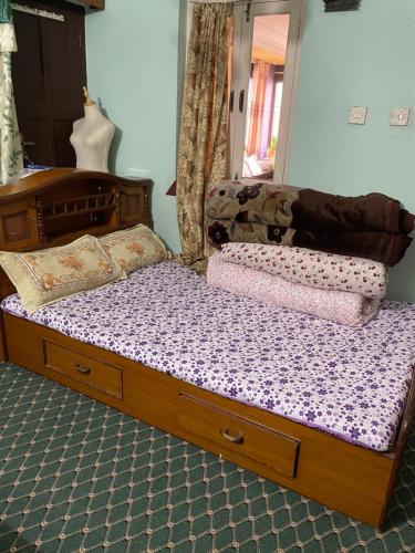 a bed with a wooden frame in a bedroom at Patan Nest in Pātan