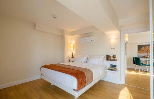 a white bedroom with a bed and a table at Batumi Sky Palace in Batumi