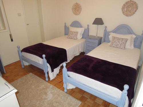 two beds in a room with blue and white at Ester Guest House in Chaves