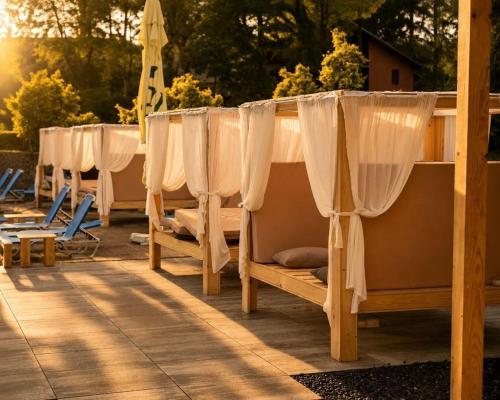a row of beds with curtains on a patio at Hotel Sallaris Monteoru in Sărata-Monteoru