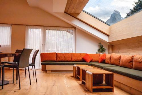 a living room with a couch and a table at central sky-penthouse with iconic matterhorn view in Zermatt