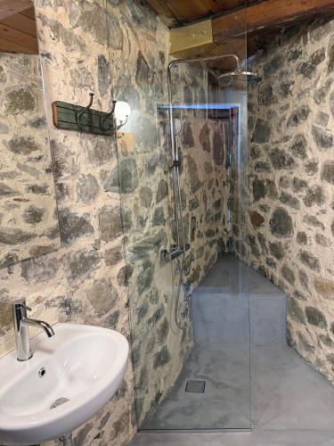 a bathroom with a sink and a glass shower at Stone Villa, Infinity Pool & Libyan Sea Views in Agia Galini