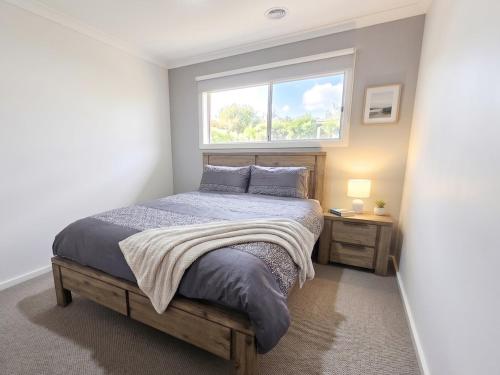 a bedroom with a bed and a window at St Germain House, Clyde North in Clyde North