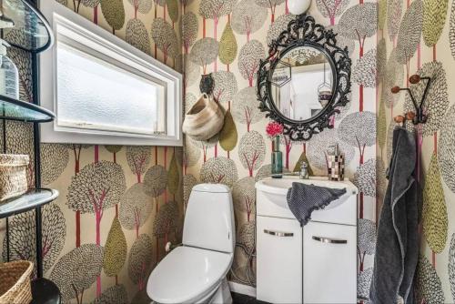 a bathroom with a toilet and a mirror at Spacious villa in Sörby in Gävle