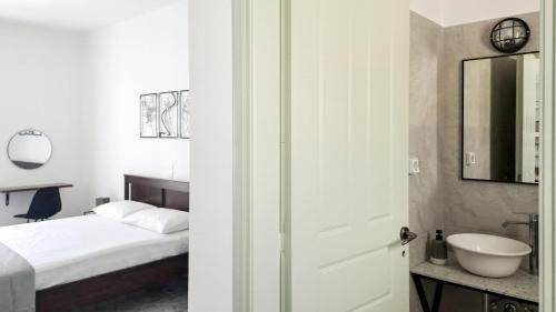 a bedroom with a bed and a sink and a mirror at Firogia Olive Grove Hideaway in Sifnos