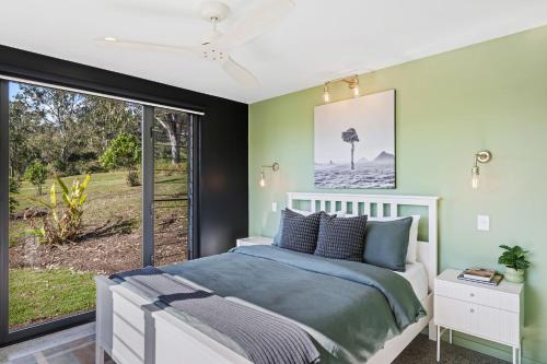 a bedroom with a bed and a large window at Dundalli Lodge in Conondale