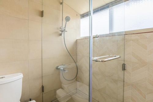 a shower with a glass door in a bathroom at Rooftop one BDR with Terrace in Al Bawsharīyah
