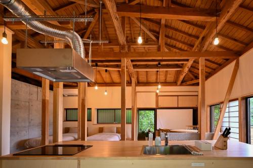 a kitchen with wooden ceilings and a stove top oven at Beppu TOJIHAUS 002 Hilltop Sea View 8min walk to Hells of Beppu in Beppu