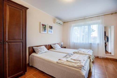 a bedroom with two beds and a window at Boka Garden in Bijela