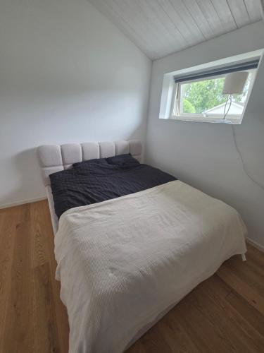 a bed in a small room with a window at Wonderfully unique accommodation in Bålsta