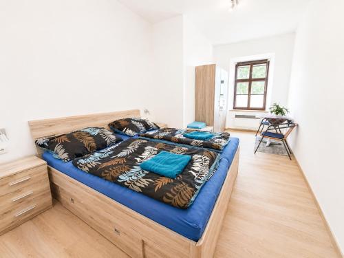 a bedroom with a large bed with blue sheets at Apartmany 123 in Broumov