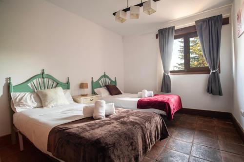 a bedroom with two beds and a window at VUT Carrascosos, oasis familiar by Cabana Rentals in El Espinar