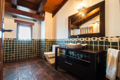 a bathroom with a sink and a toilet and a mirror at VUT Carrascosos, oasis familiar by Cabana Rentals in El Espinar
