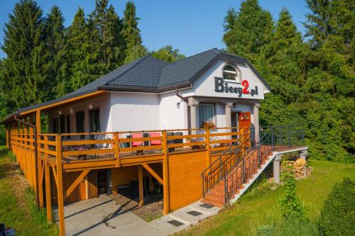 a large house with a large wooden deck at Biesy2 in Wetlina